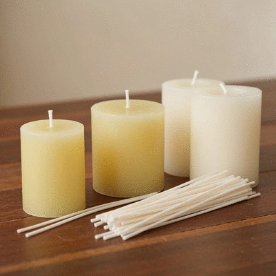 Close-up of various candle making supplies, including wax, wicks, and essential oil bottles