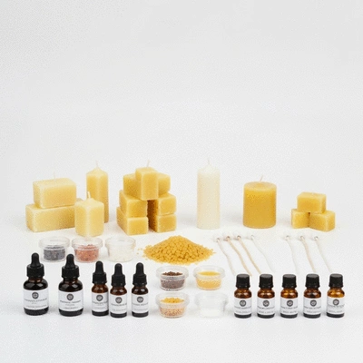 Assortment of candle making kit components including waxes, wicks, fragrance oils, and small containers on a clean background, no text, no words, no typography, clean image