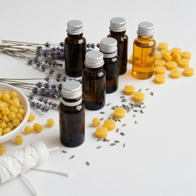 Assortment of essential oil bottles and natural candle making ingredients on a wooden table